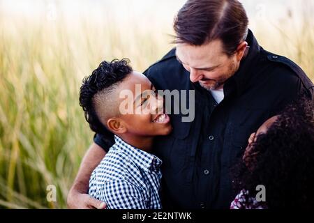 Padre e figli che abbracciano il Parco di Chula Vista Foto Stock