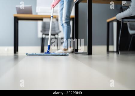 Pavimento di pulizia di Janitor femminile in ufficio o sul posto di lavoro Foto Stock