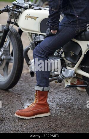 Un piccolo colpo di giovani in jeans che posano sulla moto Foto Stock