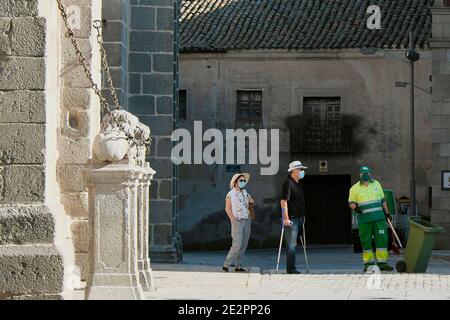 Due turisti e una spazzatrice, di fronte alla cattedrale di Ávila. Foto Stock