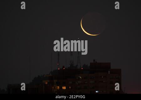 Santiago, Metropolitana, Cile. 14 gennaio 2021. La nuova luna di gennaio si nasconde dietro Cerro San Cristobal, e gli edifici di Santiago. Credit: Matias Basualdo/ZUMA Wire/Alamy Live News Foto Stock