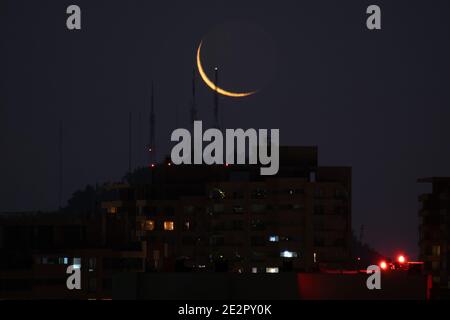 Santiago, Metropolitana, Cile. 14 gennaio 2021. La nuova luna di gennaio si nasconde dietro Cerro San Cristobal, e gli edifici di Santiago. Credit: Matias Basualdo/ZUMA Wire/Alamy Live News Foto Stock