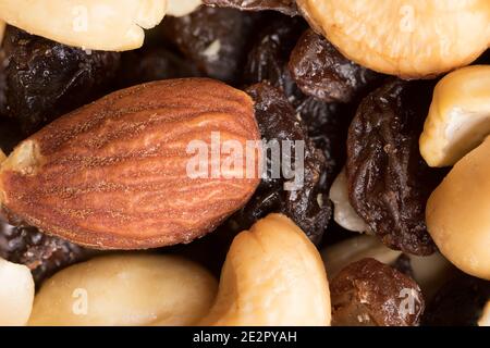 Un'immagine macro di uva passa e noci in un sano trail-mix pronto per lo snacking Foto Stock