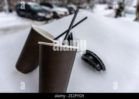 Due tazze di carta con caffè mantengono caldo su una sciarpa nella neve, racconto d'amore invernale Foto Stock