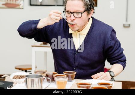 Barista professionista che verifica il gusto di un nuovo caffè Foto Stock