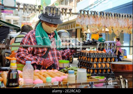 China Town, Bangkok, Thailandia - 14 novembre 2020: Un venditore di cibo di strada deve sempre indossare una maschera protettiva mentre vende il suo cibo. Foto Stock