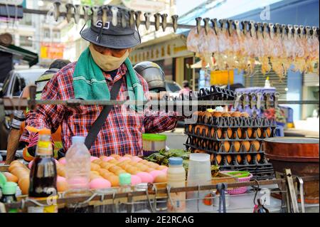 China Town, Bangkok, Thailandia - 14 novembre 2020: Un venditore di cibo di strada deve sempre indossare una maschera protettiva mentre vende il suo cibo. Foto Stock