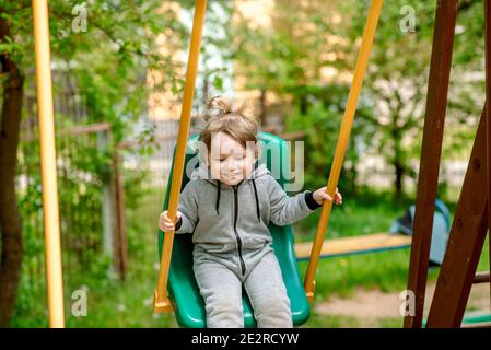 Ridere bambino in swing in estate park.plays giochi, corse e salti per bambini. Infanzia spensierata. Foto Stock