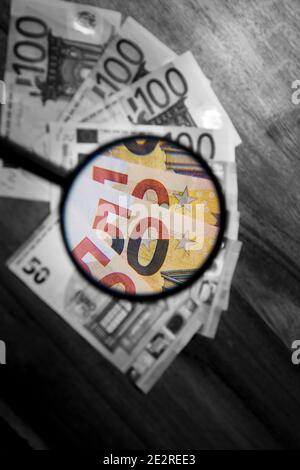 Ingrandimento con una lente di ingrandimento del valore di un gruppo di euro. La vista ingrandita è a colori e il resto è in bianco e nero Foto Stock