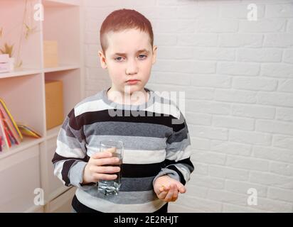 Cute bambino rifiuta di prendere il farmaco che viene offerto Foto Stock