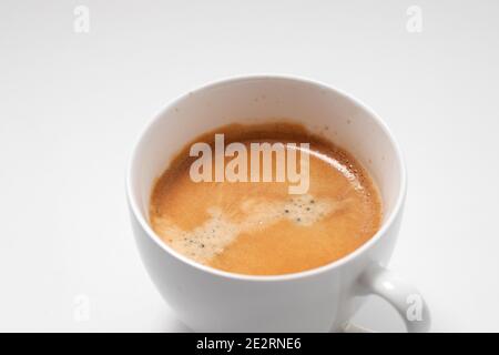 Preparazione della crema di caffè sul caffè appena preparato. Tazza di cappuccino in tazza bianca. Foto Stock