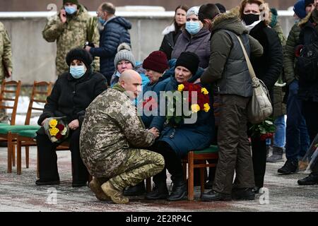 Non esclusivo: ZAPORIZHZHIA, UCRAINA - 14 GENNAIO 2021 - la madre e un fratello maggiore del soldato perito Oleh Andrienko grieve durante la funera Foto Stock