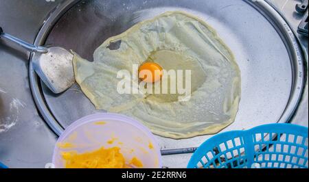 Preparazione di deliziosi pancake con un ripieno di banana a Negozio mobile Street food in Thailandia Foto Stock