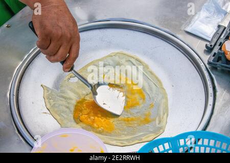 Preparazione di deliziosi pancake con un ripieno di banana a Negozio mobile Street food in Thailandia Foto Stock