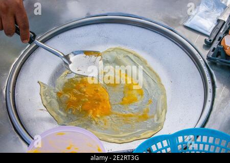 Preparazione di deliziosi pancake con un ripieno di banana a Negozio mobile Street food in Thailandia Foto Stock