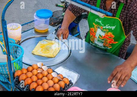 Preparazione di deliziosi pancake con un ripieno di banana a Negozio mobile Street food in Thailandia Foto Stock