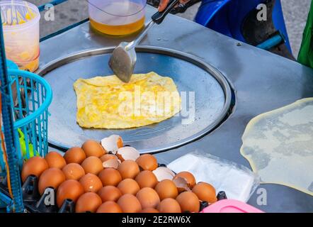 Preparazione di deliziosi pancake con un ripieno di banana a Negozio mobile Street food in Thailandia Foto Stock