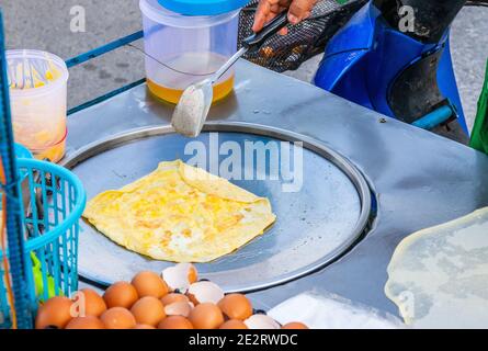 Preparazione di deliziosi pancake con un ripieno di banana a Negozio mobile Street food in Thailandia Foto Stock