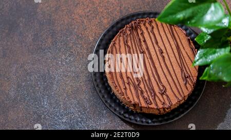 Cheesecake al cioccolato classico su sfondo scuro. Cottura fatta in casa. Vista dall'alto. Foto Stock