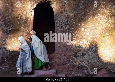 Pellegrini profondamente religiosi che pregano e baciano il muro della Chiesa scavata nella roccia, Felsenkirche, patrimonio dell'umanità dell'UNESCO, Lalibela, Etiopia, Africa Foto Stock