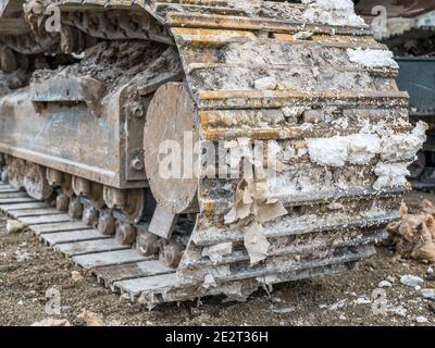 Primo piano con i cingoli a catena di un apripista acceso un sito di demolizione Foto Stock