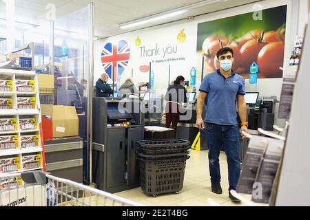 Ashford, Kent, Regno Unito. 15 gennaio 2021. Un negozio Lidl nella città Kent di Ashford. Poche persone stanno facendo i loro negozi quotidiani in negozio con il governo incoraggiando clic e raccogliere e consegne. Tutti gli acquirenti indossano maschere facciali, ad eccezione del personale addetto al check out. Area self-service con un membro del personale che indossa una maschera facciale. Photo Credit: Paul Lawrenson/Alamy Live News Foto Stock