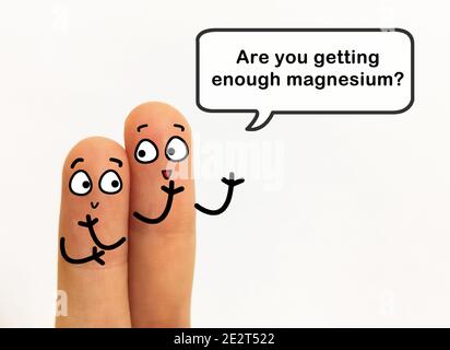 Due dita sono decorate come due persone. Uno di loro sta chiedendo ad un altro se sta ottenendo abbastanza magnesio. Foto Stock