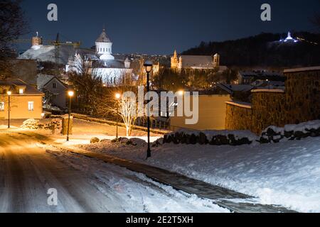 Vista panoramica della città vecchia di Vilnius, vista notturna o serale con castello, chiesa e vecchi edifici e lampada da strada in inverno con neve Foto Stock
