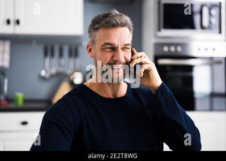 Comunicazione con il Business Desk. Giovane uomo che parla al telefono Foto Stock