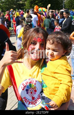 ADANA, TURCHIA-9 APRILE: Ragazza non identificata clown che tiene un bambino carino e che posa Al Carnevale di Orange Blossom.April 9,2017 ad Adana, Turchia Foto Stock