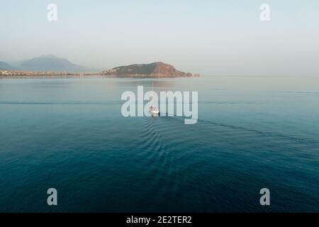 Barca a vela sul mare nella brezza del mattino su uno splendido sfondo di grandi montagne, avventura estiva, vacanze attive nel Mediterraneo, Turchia Foto Stock