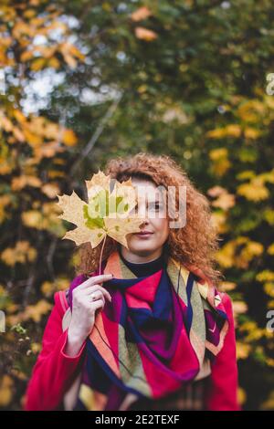 Gravidanza, maternità e felicità. Elegante giovane donna incinta che riposa nel parco autunnale. Bella donna che si aspetta il bambino, godendo momento dolce Foto Stock