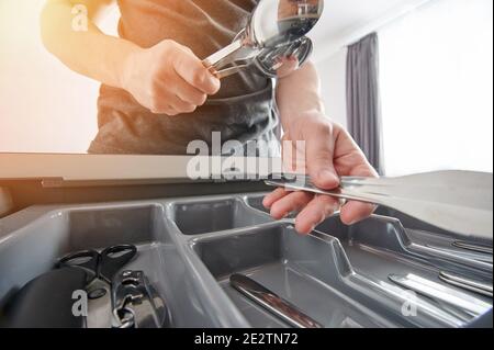 Utensili da cucina in acciaio inox puliti su sfondo di plastica Foto Stock