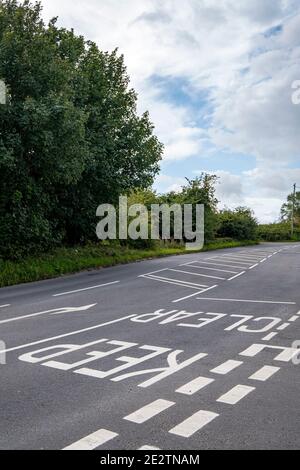 Tenere chiaro informazioni sul traffico dipinto su strada asfaltata a Cheshire REGNO UNITO Foto Stock