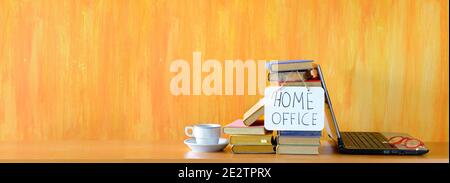 home offiice, istruzione, business, concetto con computer portatile fila di libri e messaggi segno, panoramico, spazio libero copia Foto Stock