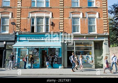 EarlyBird Cards negozio con persone tra cui ciclista che parlano all'esterno e persone che passano. Una trafficata strada urbana Stoke Newington Church Street Londra Foto Stock