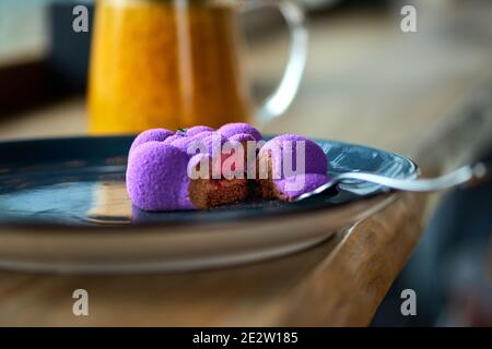 Mini dessert alla mousse francese con copertina di velluto viola sul tavolo, serve in un ristorante, menu'. Foto Stock