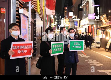 15 gennaio 2018, Tokyo, Giappone - gli ufficiali del governo locale tengono i cartelli e chiedono alle persone di rimanere a casa nel quartiere della moda Shibuya in mezzo allo scoppio del nuovo coronavirus a Tokyo venerdì 15 gennaio 2021. Il governo giapponese ha dichiarato lo stato di emergenza su Tokyo e su altre 10 prefetture questa settimana e ha chiesto nightclub e ristoranti di chiudere le 20:00. (Foto di Yoshio Tsunoda/AFLO) Foto Stock