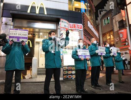 15 gennaio 2018, Tokyo, Giappone - gli ufficiali del governo locale tengono i cartelli e chiedono alle persone di rimanere a casa nel quartiere della moda Shibuya in mezzo allo scoppio del nuovo coronavirus a Tokyo venerdì 15 gennaio 2021. Il governo giapponese ha dichiarato lo stato di emergenza su Tokyo e su altre 10 prefetture questa settimana e ha chiesto nightclub e ristoranti di chiudere le 20:00. (Foto di Yoshio Tsunoda/AFLO) Foto Stock