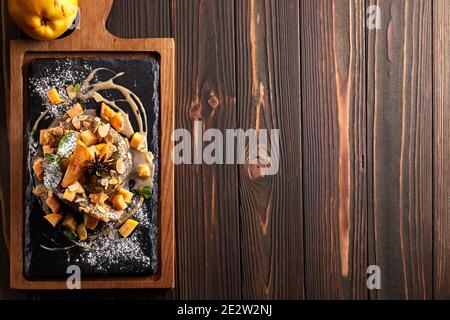 Pancake con salmone, su pietra nera, ardesia, su tavola di legno. Vista dall'alto Foto Stock