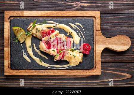 Pancake con salmone, su pietra nera, ardesia, su tavola di legno Foto Stock