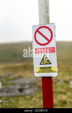 Un cartello di avvertimento su un palo segnaletico indica il confine del campo di tiro di Merrivale sul Parco Nazionale di Dartmoor. Foto Stock