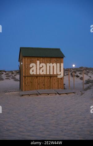 Case di legno per pescatori su una spiaggia vuota di notte a Comporta, Portogallo Foto Stock
