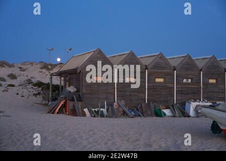 Case di legno per pescatori su una spiaggia vuota di notte a Comporta, Portogallo Foto Stock