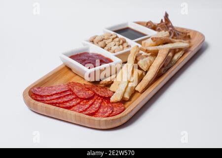 antipasti di birra con arachidi, salumi, toast e formaggi su tavola di legno isolata Foto Stock