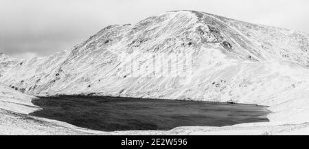 Una neve Fairfield e Grisedale Tarn nel Lake District National Park, Cumbria Foto Stock