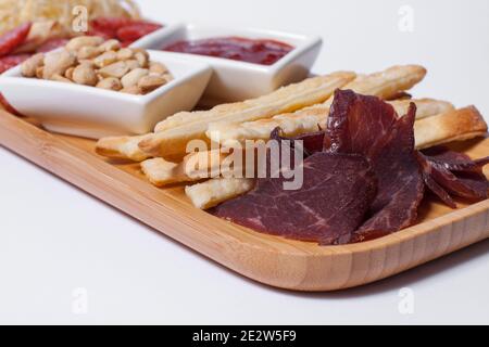 set di spuntini alla birra con salumi, arachidi, formaggio cheddar e ketchup Foto Stock