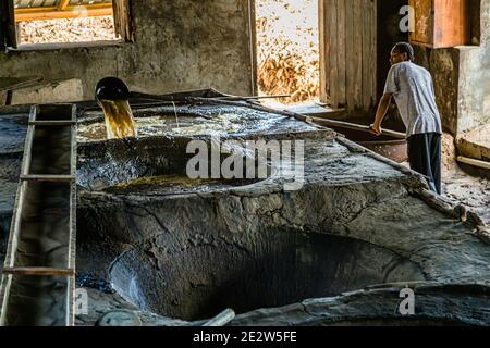 Mura di mattoni e un pavimento di pietra bagnato caratterizzano l'interno della distilleria di rum Antoine Rivers a La Poterie, Saint Patrick, Grenada. Foto Stock