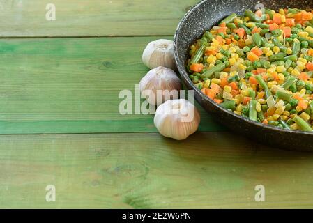 Mescolare le verdure fritte nel wok su sfondo di legno. Spazio di copia. Concetto di cibo sano. Foto Stock