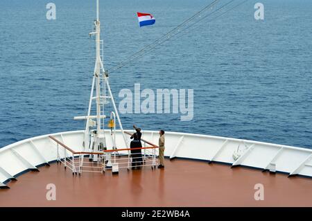 Alzando la bandiera olandese su una nave al mattino Foto Stock